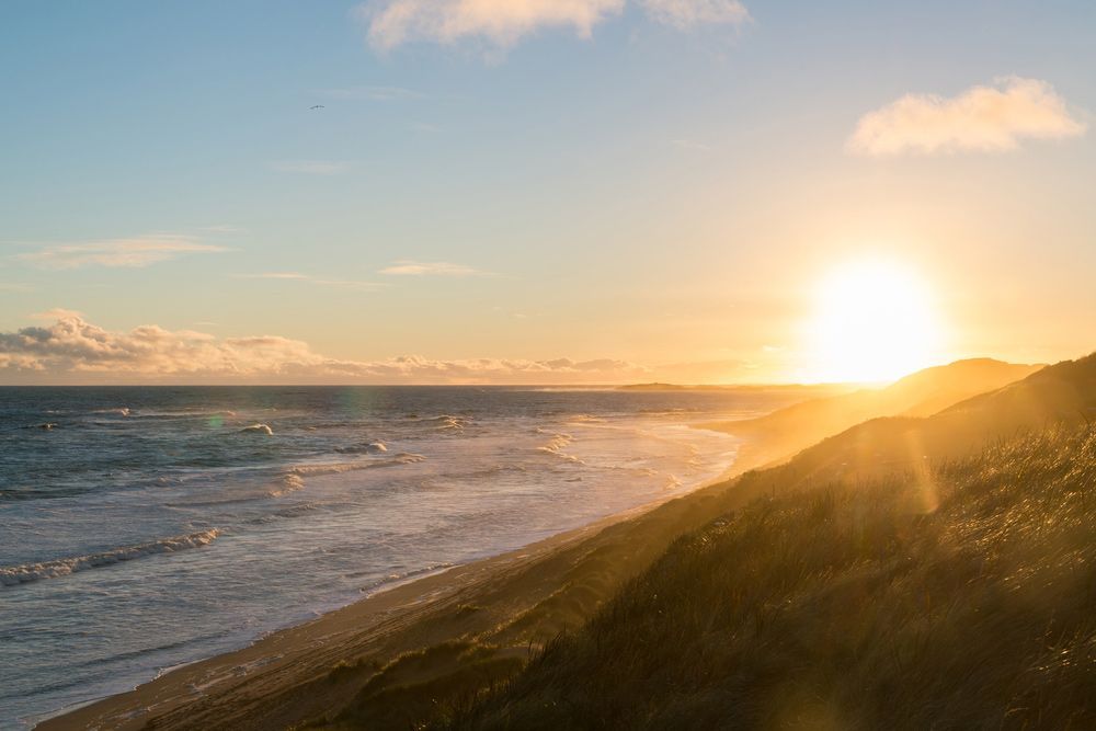 The Sun Is Setting Over the Ocean and A Beach — Ryde Energy in Logan, QLD