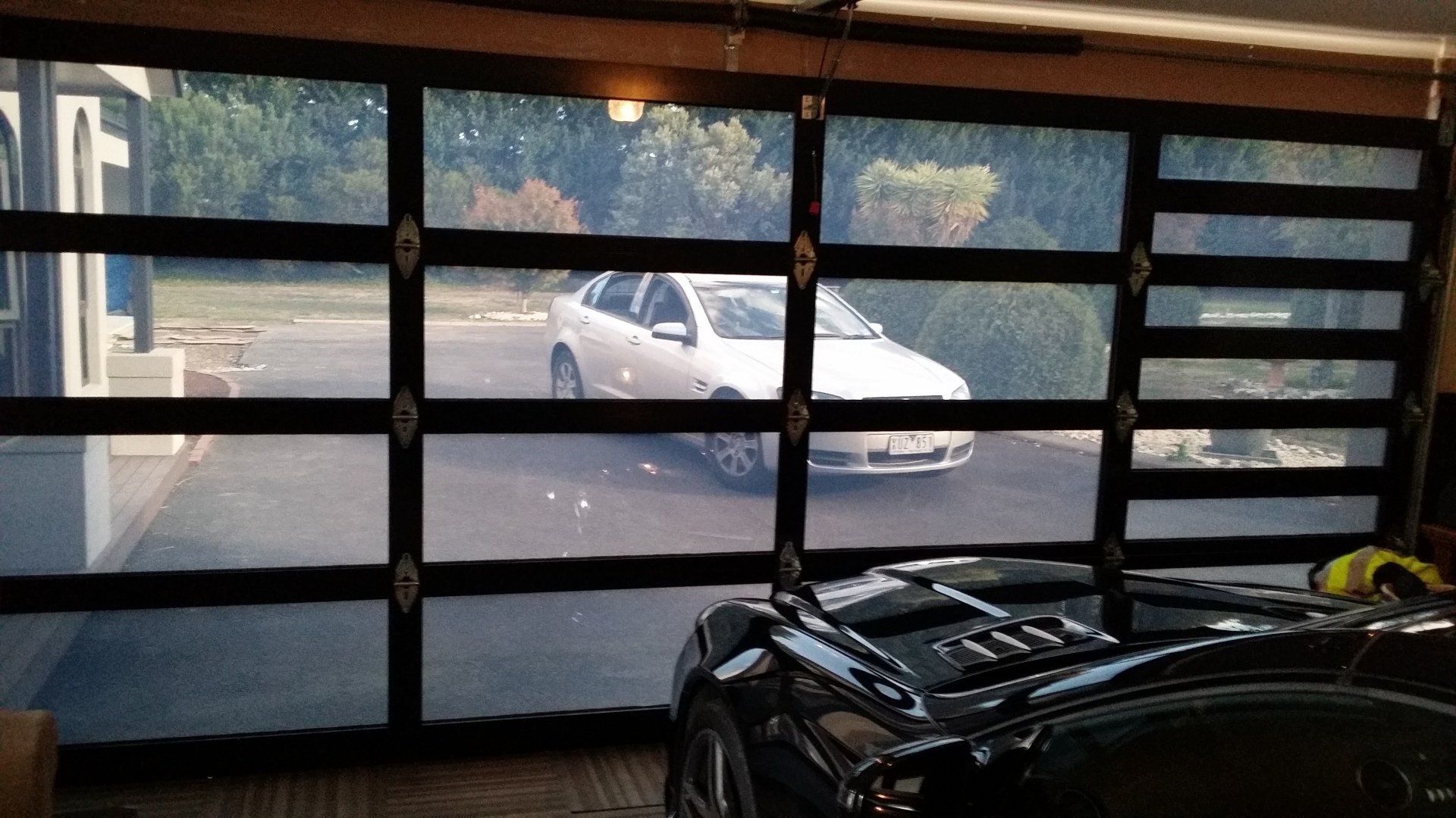 A car is parked in a garage with a large garage door