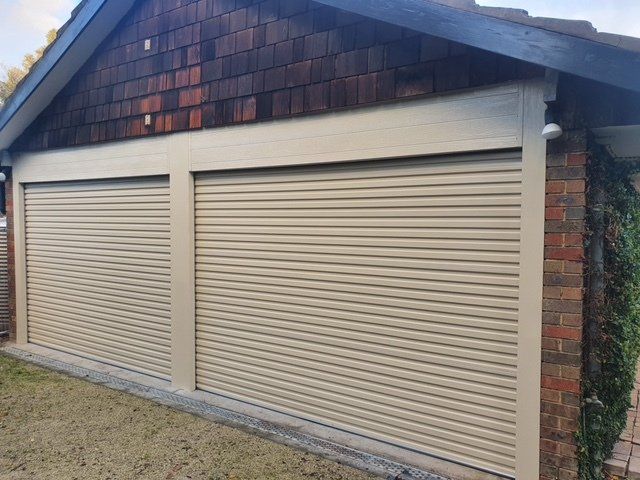 A garage with a brick roof and tan shutters