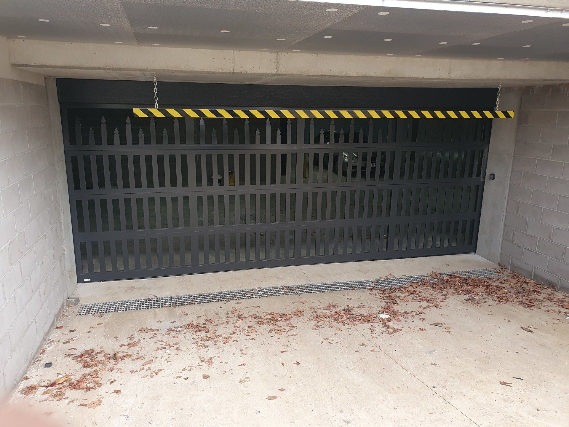 A black garage door with yellow stripes on it