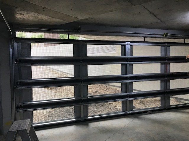 A garage door with a lot of windows and a ladder in front of it.