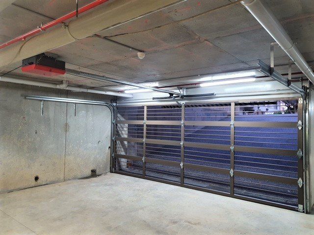 An empty garage with a large garage door open