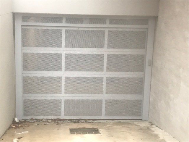 A white garage door is closed in a room.