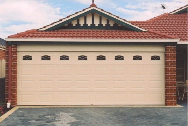 A house with a white garage door and a red roof
