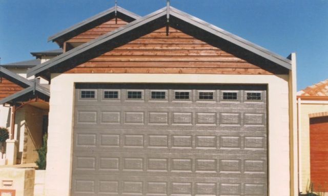 A garage door is open in front of a house