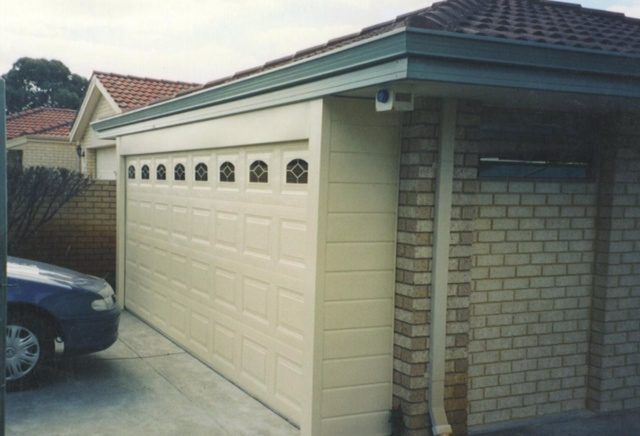 A car is parked in front of a white garage door