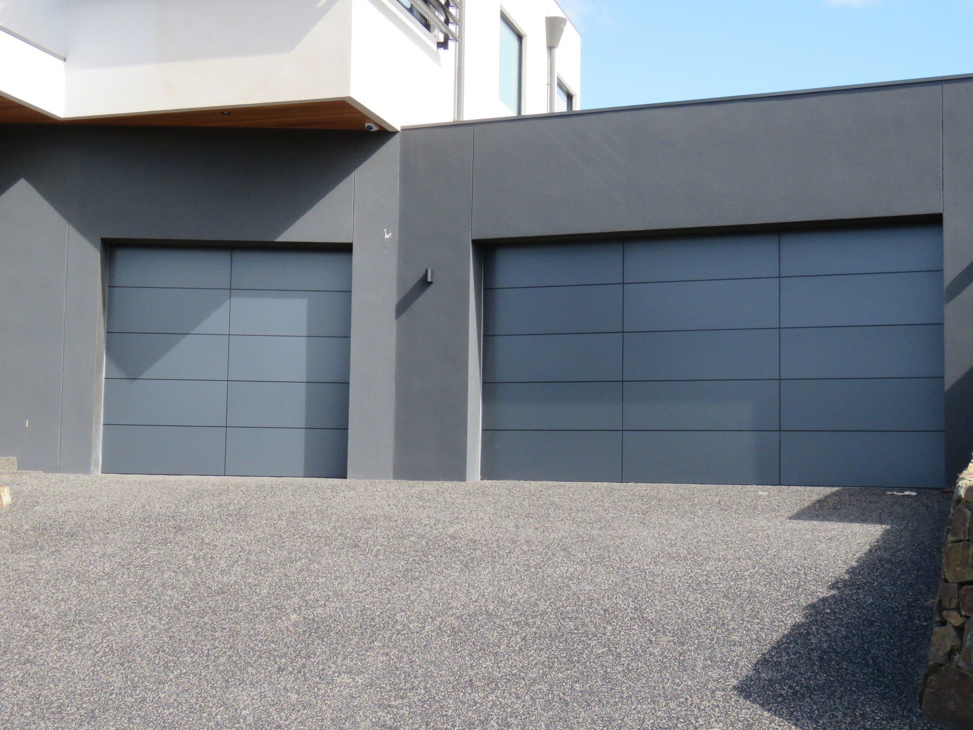 A gray garage door sits in front of a building