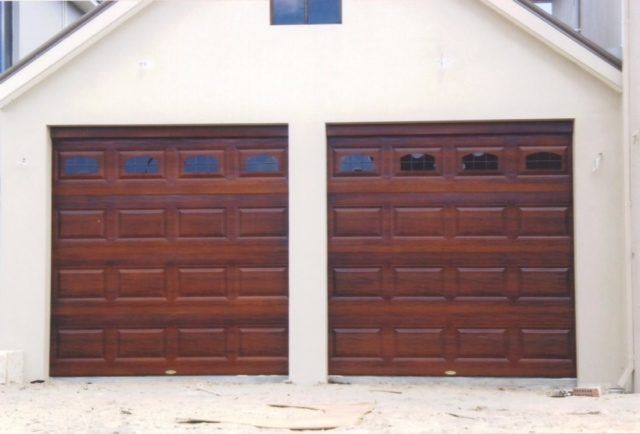 A white building with two wooden garage doors