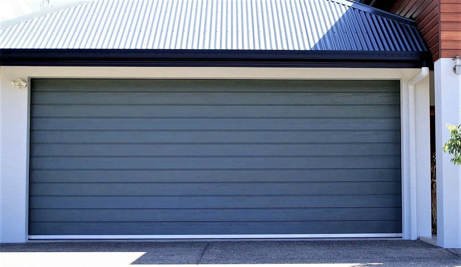 A garage door is open in front of a house.