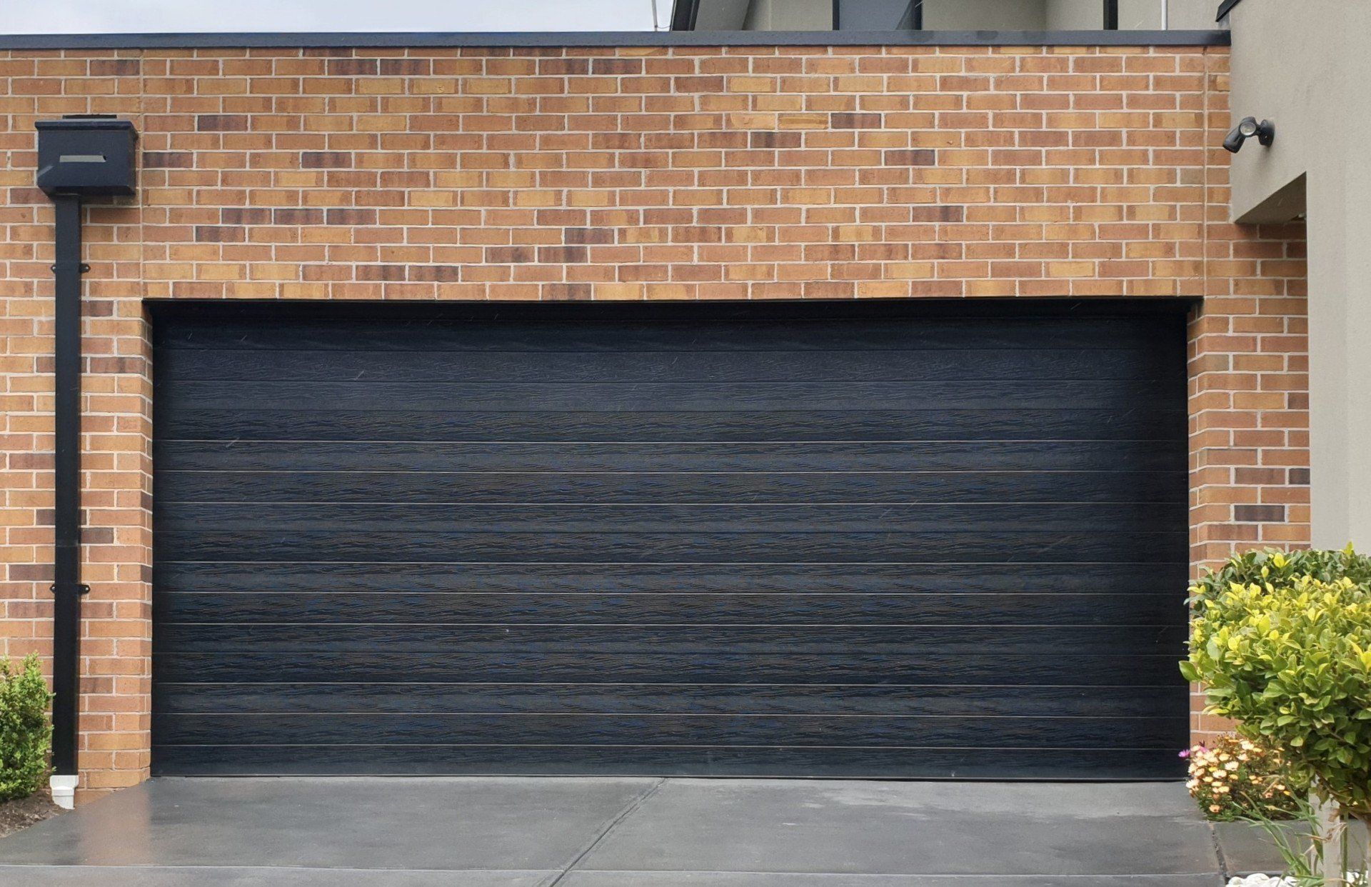 A brick building with a black garage door