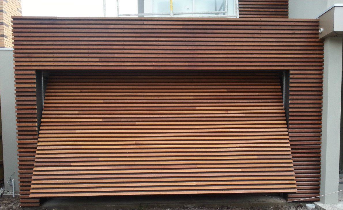 A wooden garage door is open on a house.