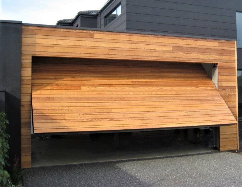 A wooden garage door is open in front of a house