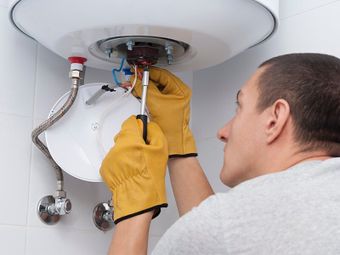 Plumber Fixing a Hot Water System — Plumber in Moranbah, QLD