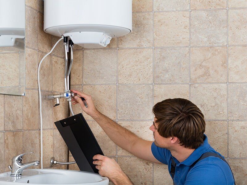 Plumber Inspecting a Hot Water System — Hot Water System Installation in Moranbah, QLD