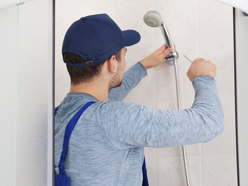 Plumber Fixing a Shower Head — Questions About Plumbing in Moranbah, QLD
