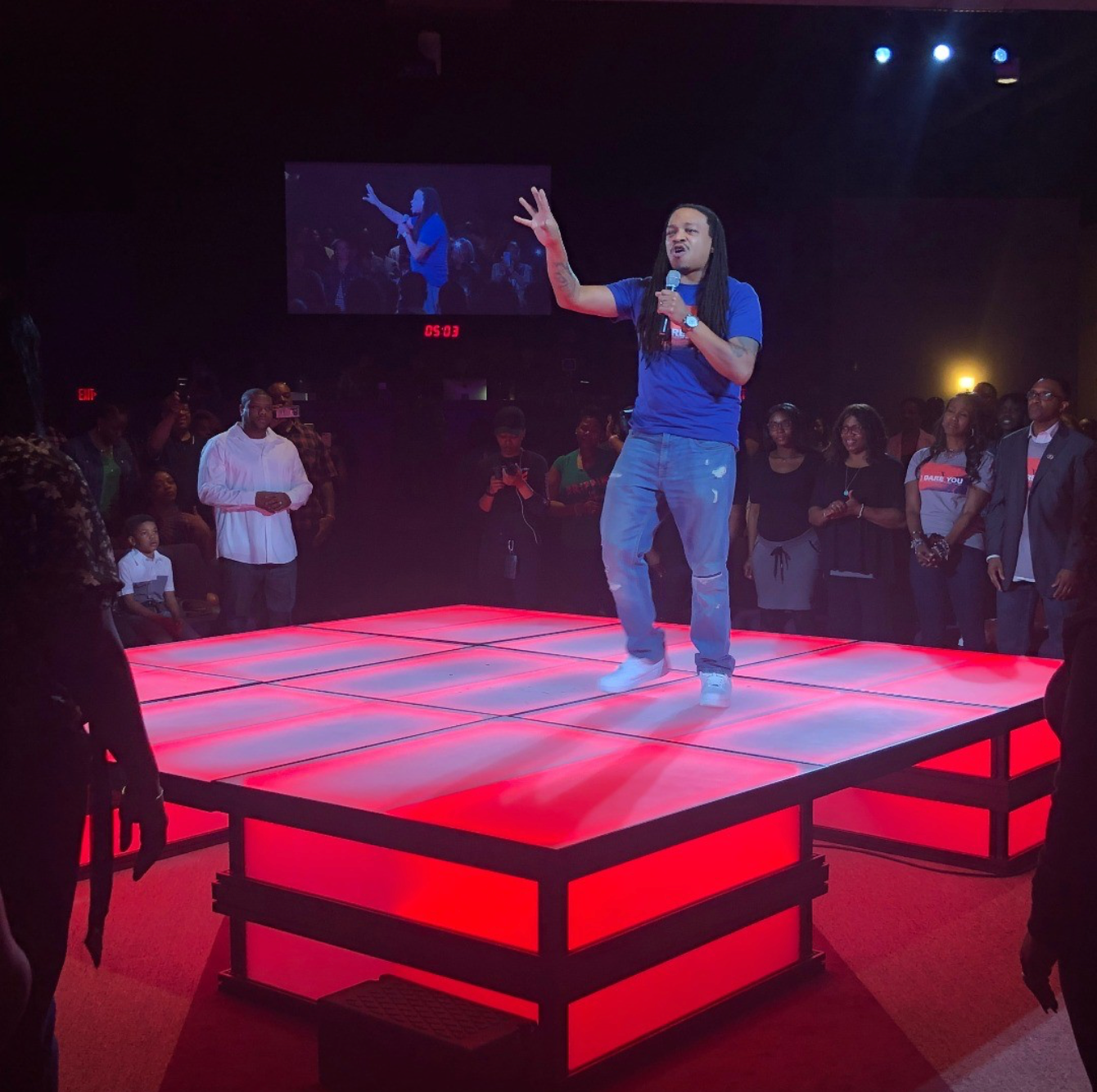 A man singing into a microphone on a stage