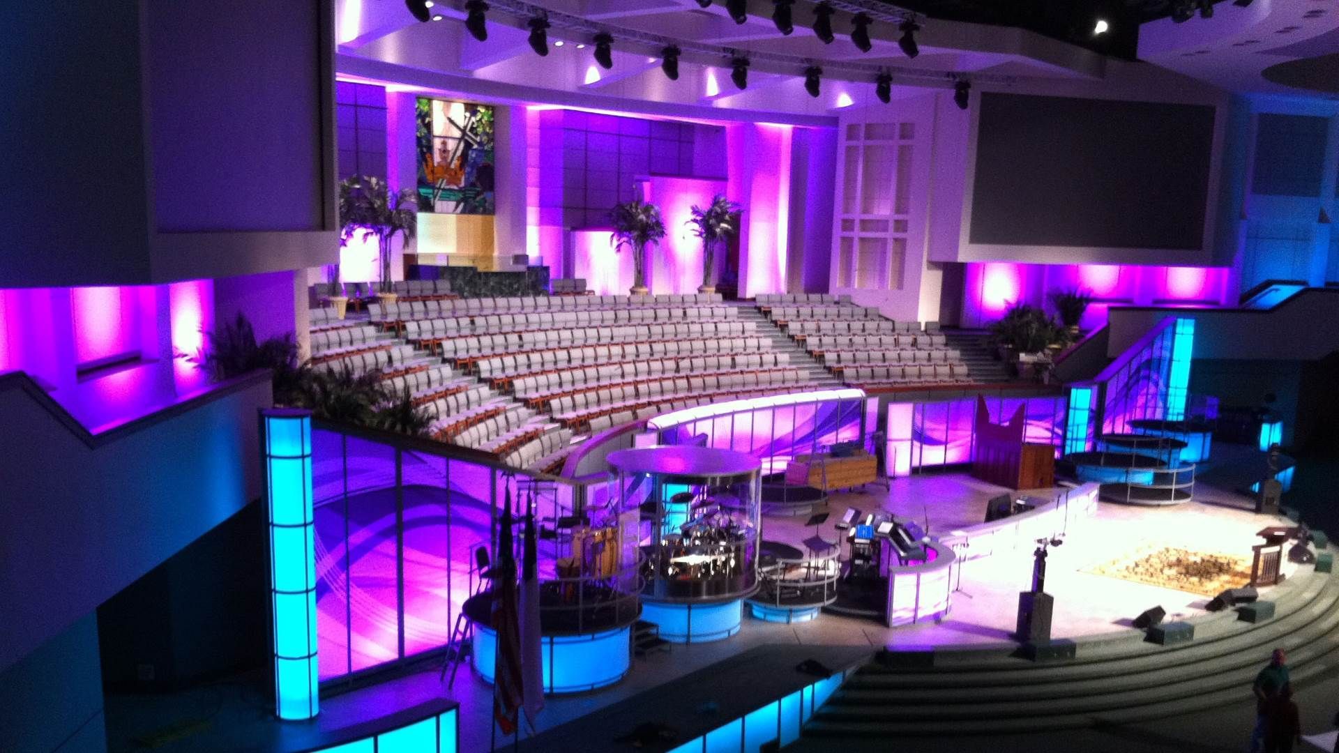 A large auditorium with purple and blue lights and a stage.