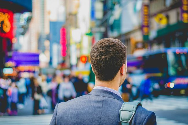 A man in a suit is walking down a city street.