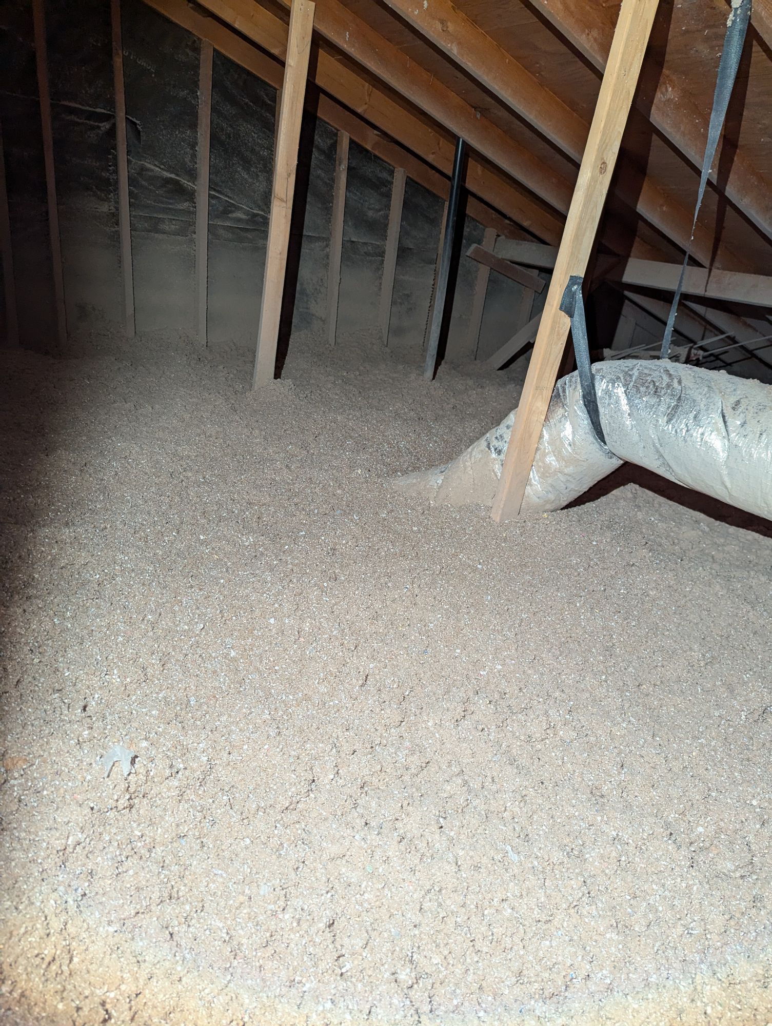 There is a pipe in the attic that is filled with insulation.