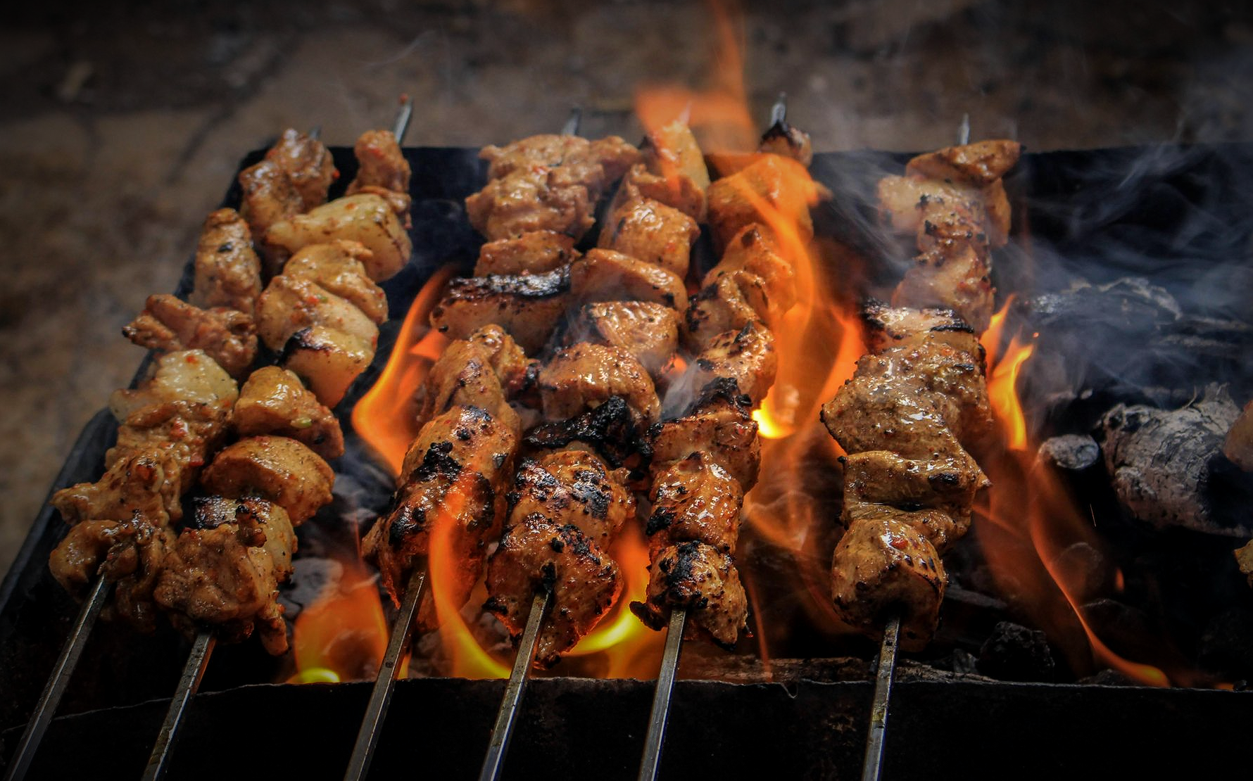 Grilled skewers of meat over flames.