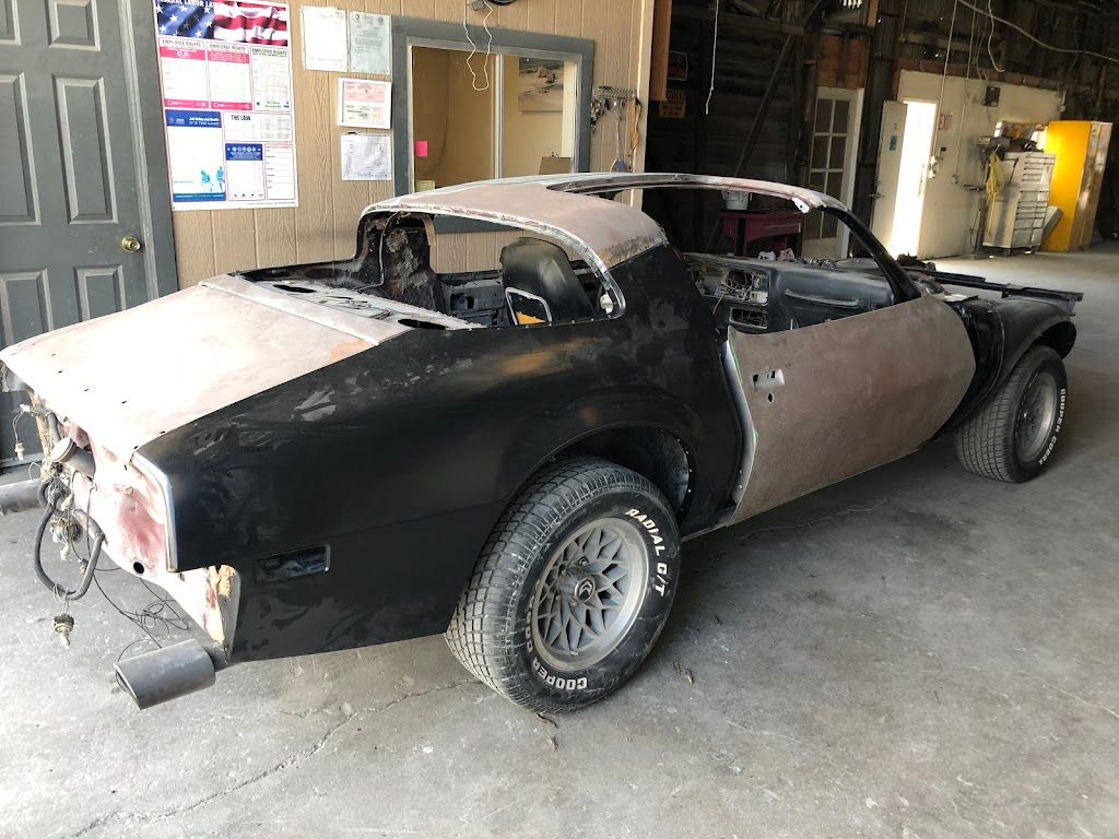 A black and brown car is sitting in a garage.