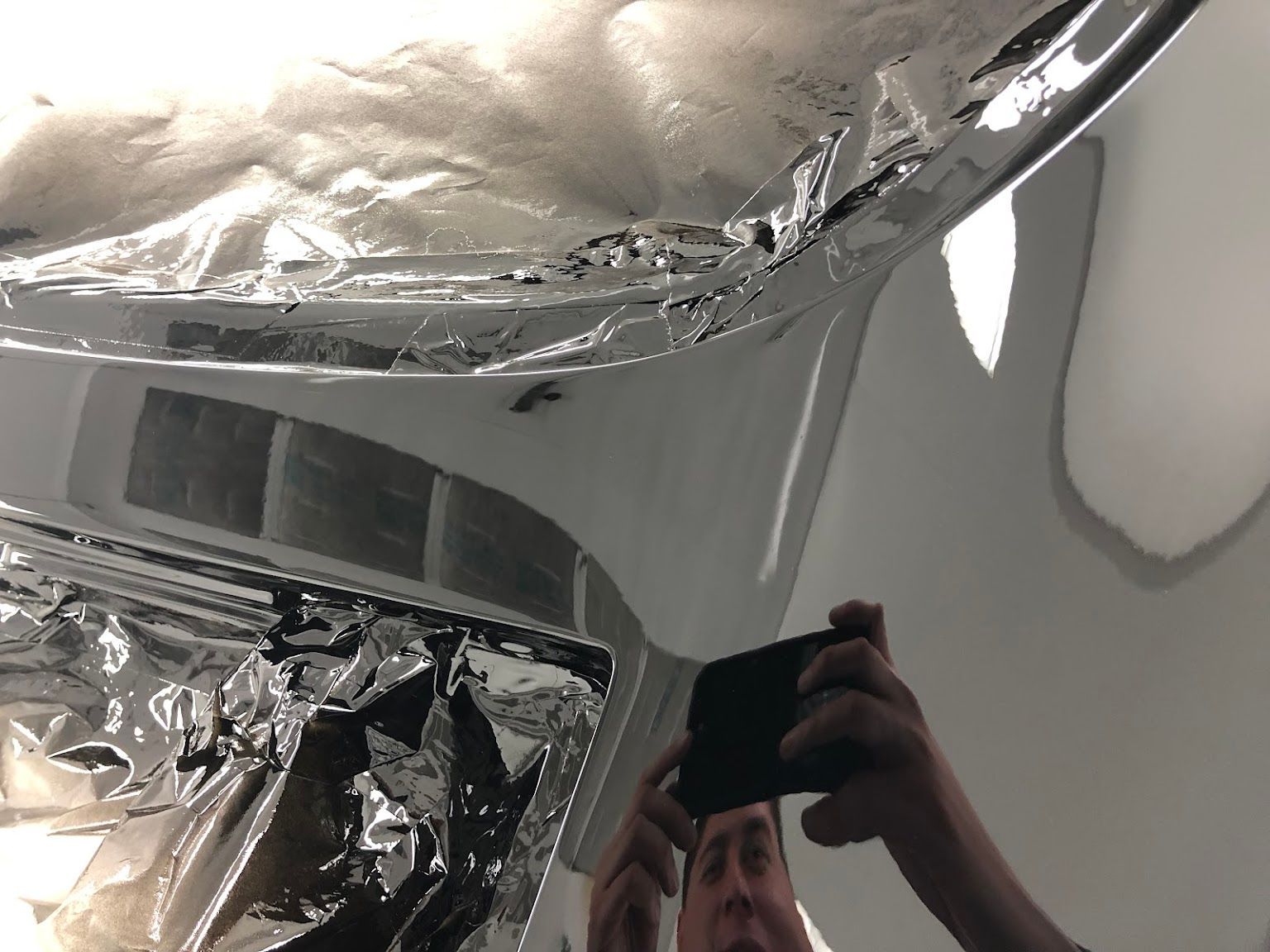 A person is taking a picture of a ceiling with a cell phone