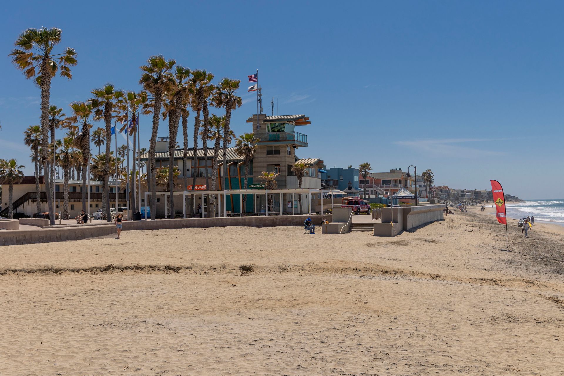 a beach with palm trees and a lifeguard tower