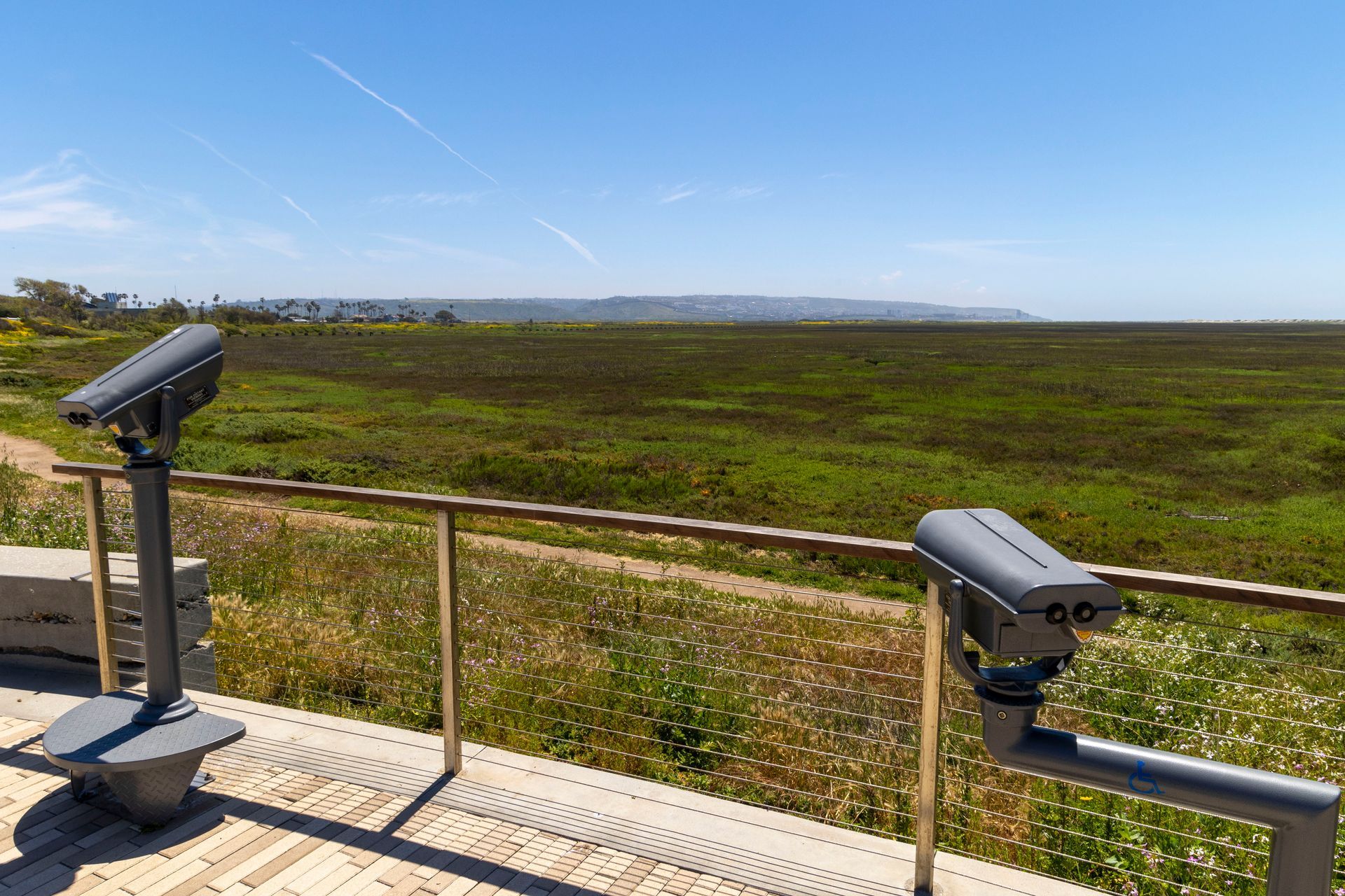 a pair of binoculars on a deck overlooking a grassy field