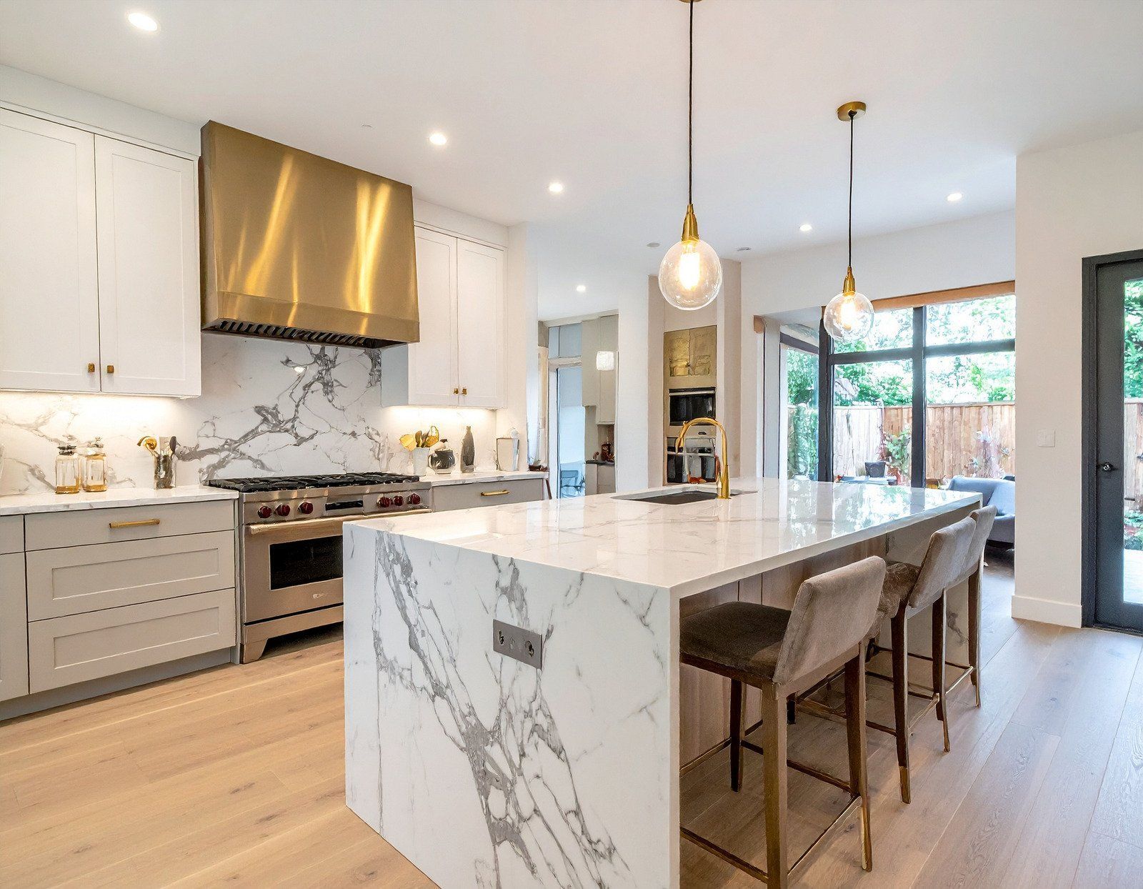 A kitchen with a large island and marble counter tops.