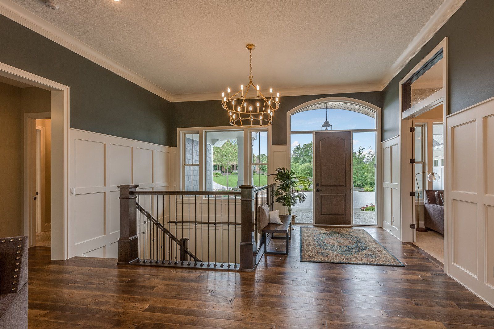 A large hallway with hardwood floors and a chandelier hanging from the ceiling.