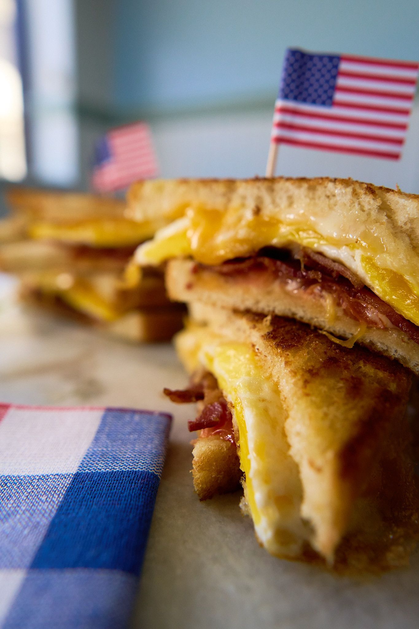 A close up of a sandwich with an american flag sticking out of it.