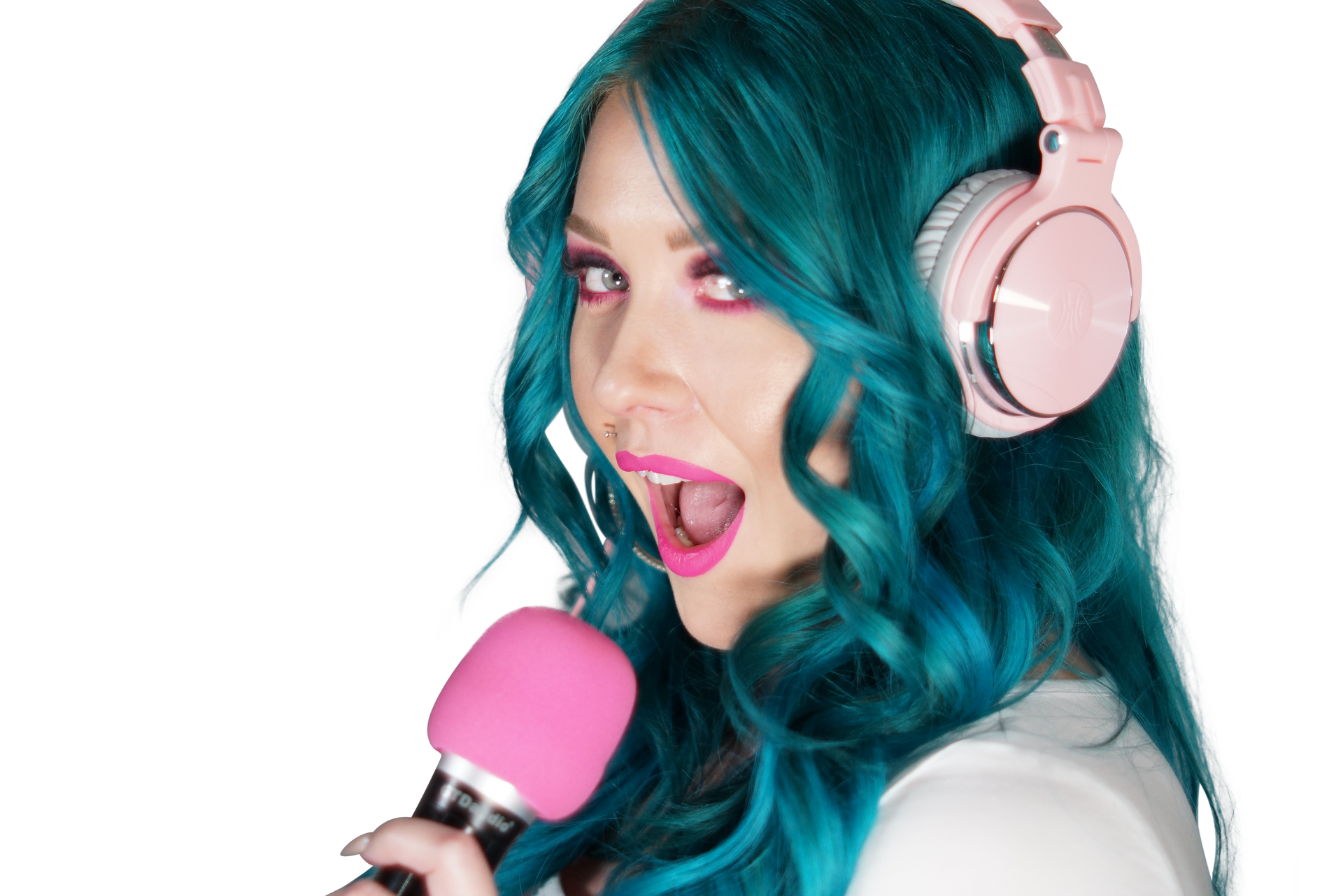 A woman with blue hair and pink headphones is singing into a pink microphone.