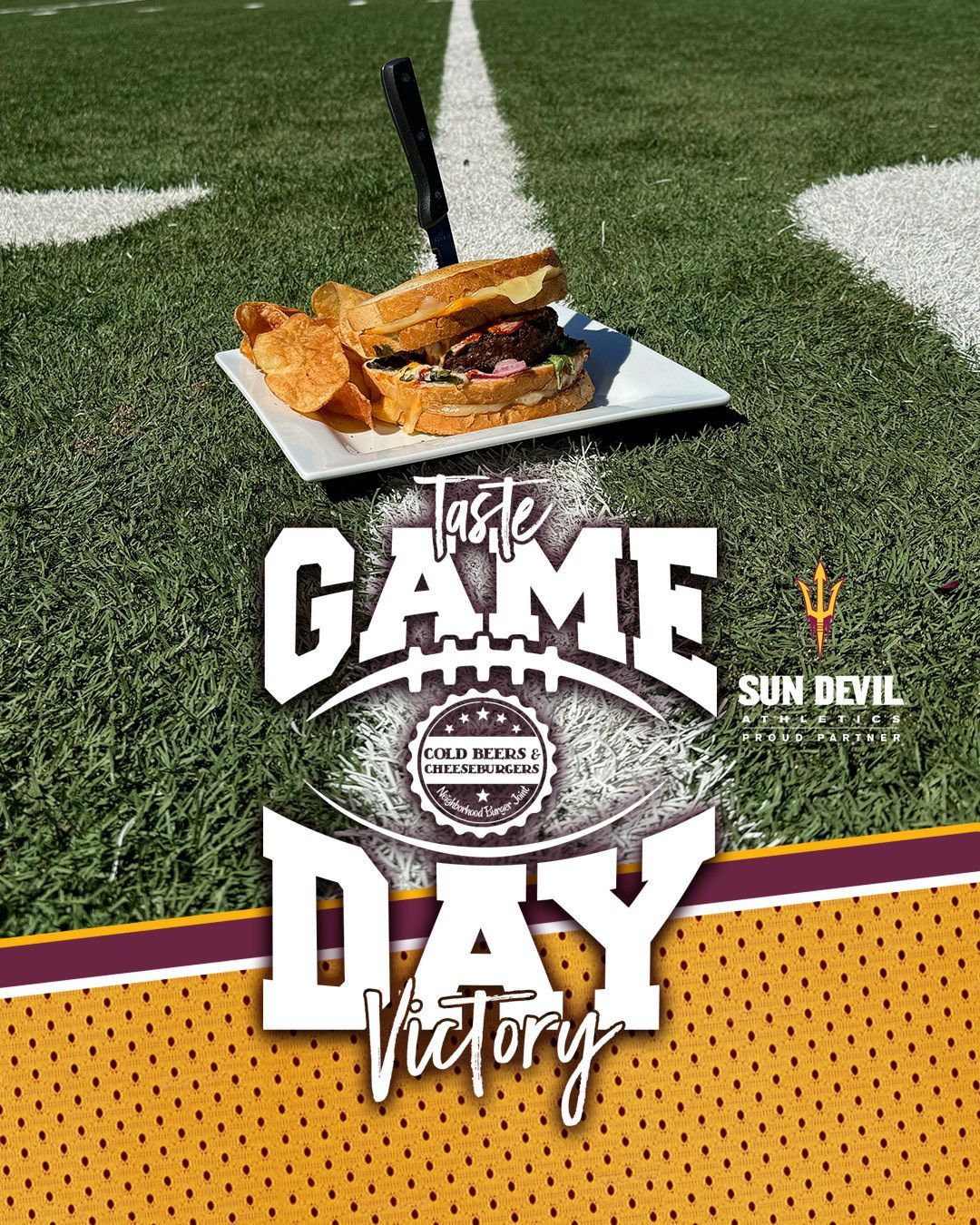 A sandwich and chips are on a plate on a football field.