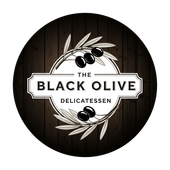 Het logo van Black Olive Delicatessen: zwarte olijven op een tak in een embleem op een houten achtergrond.