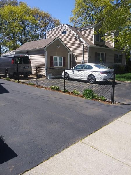 A white car is parked in front of a house