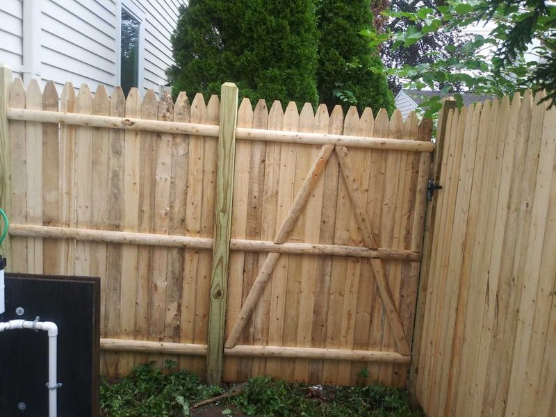A wooden fence with a gate in the backyard
