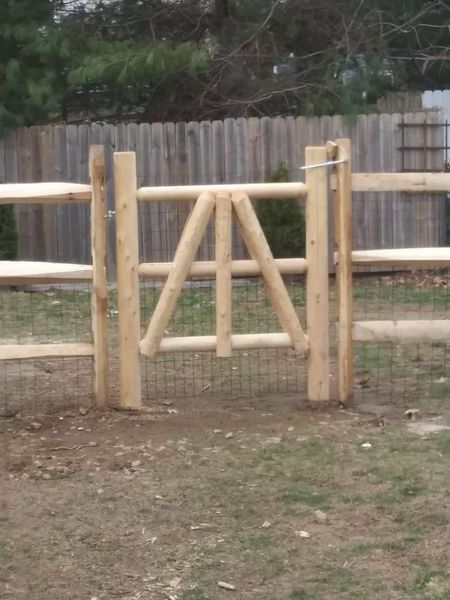 A wooden fence with a gate in the middle of it