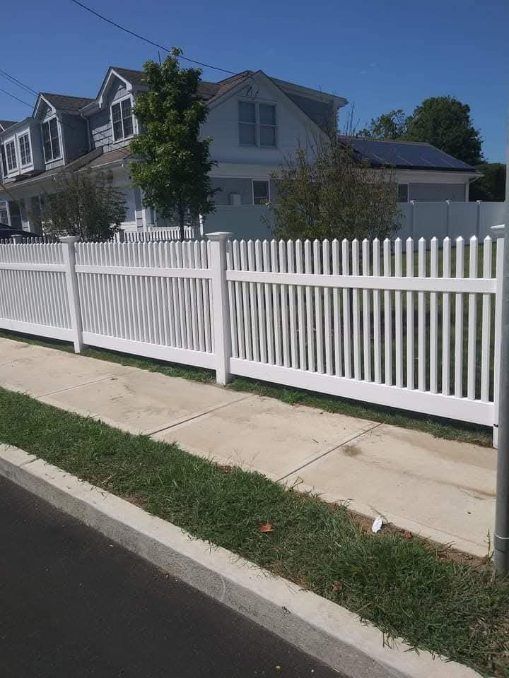 A man is using a drill to install a chain link fence.