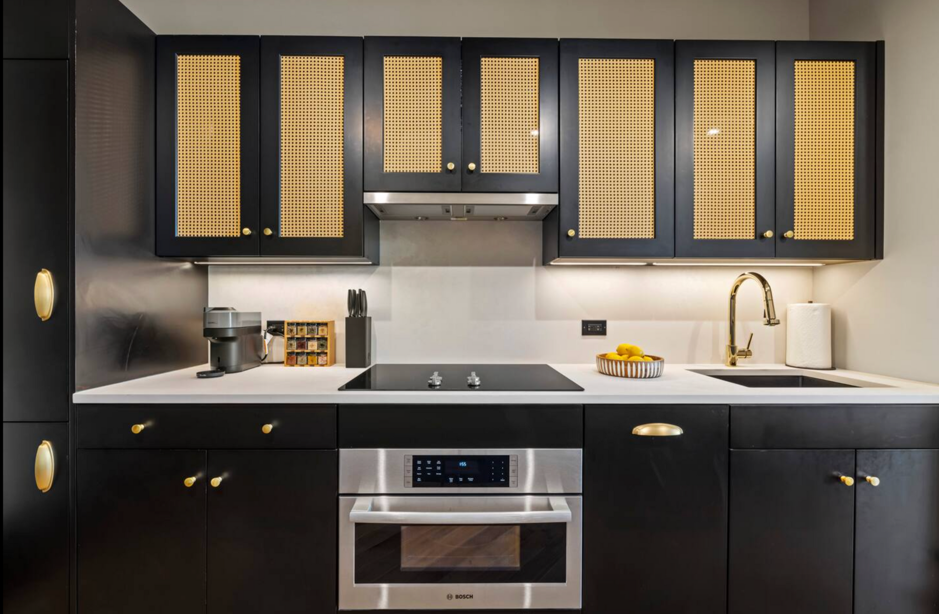 Black kitchen with gold accents; cabinets, appliances, and countertops.