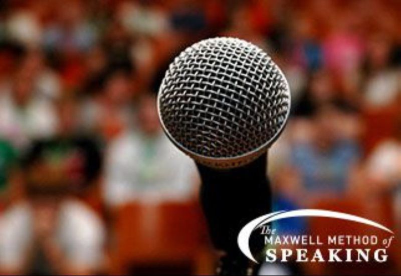 Close-up of a microphone in front of an out-of-focus crowd, with 