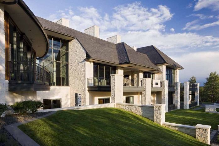 Stone building with multiple levels, tall windows, and curved roof against a blue sky.