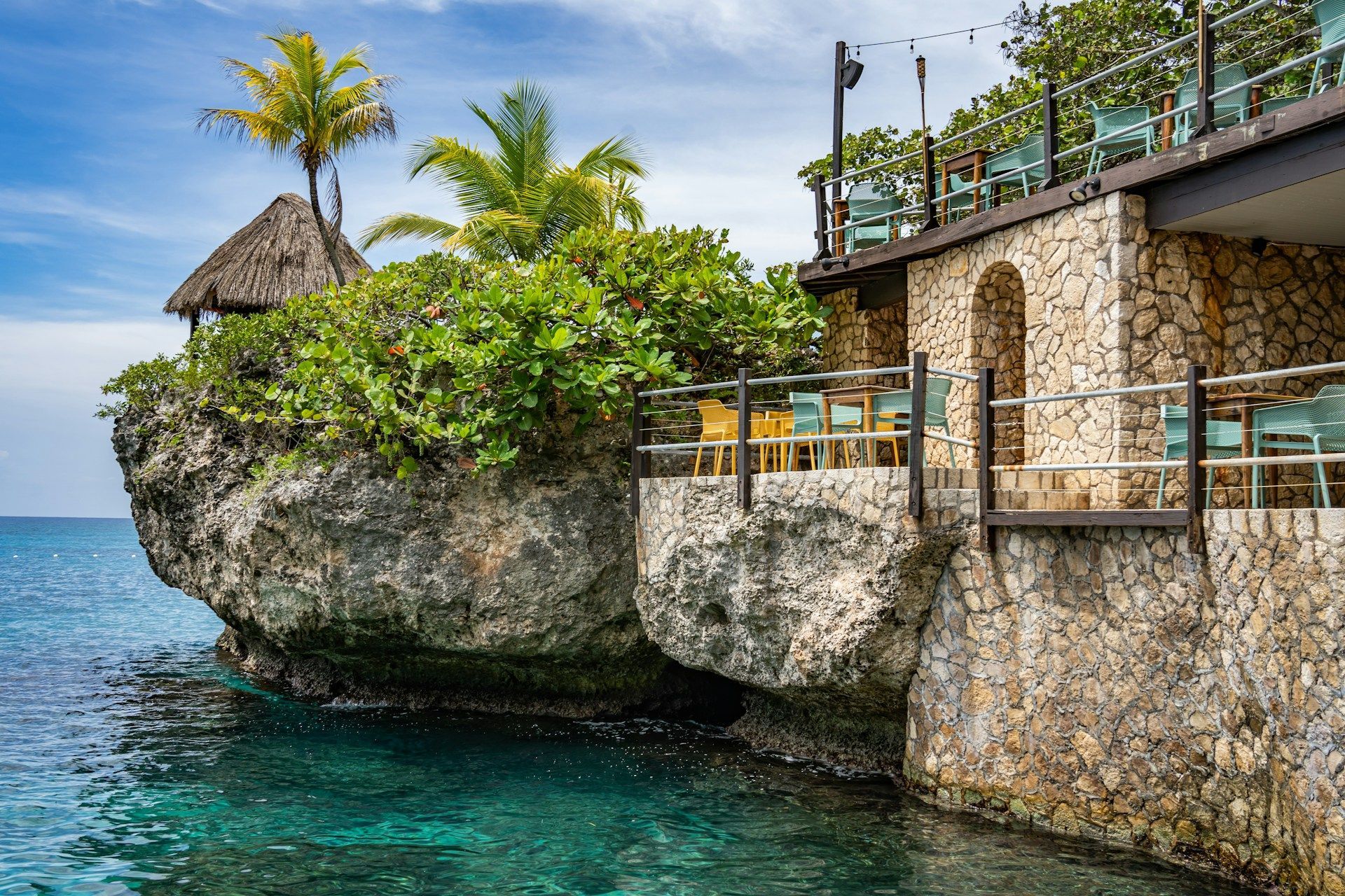 A stone building is sitting on top of a rock overlooking the ocean.