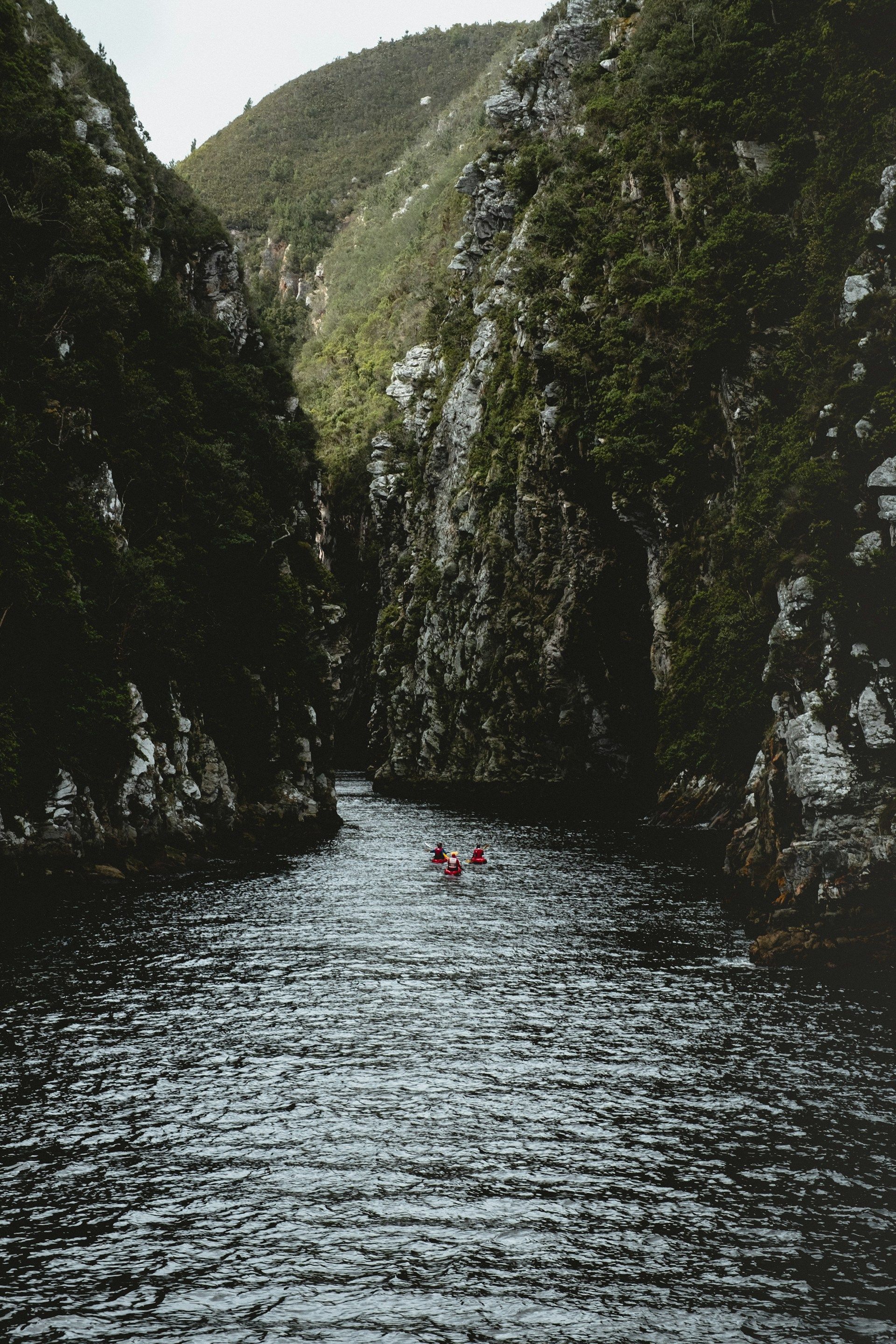 A group of people are floating down a river in a canyon.