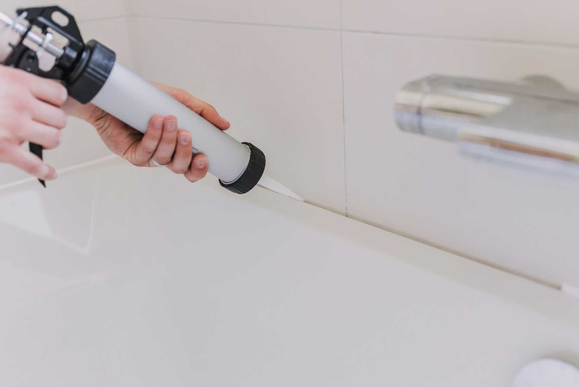 hands of man putting a silicon with a silicon tube in bathroom