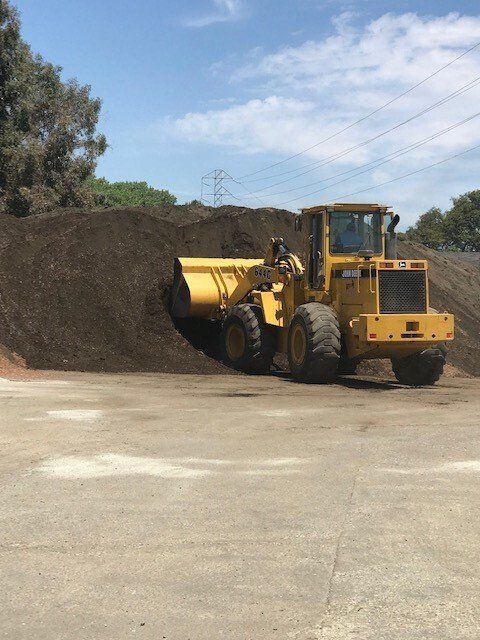 Loader truck scooping garden soil | San Mateo, CA | Bayside Building Materials, Inc.