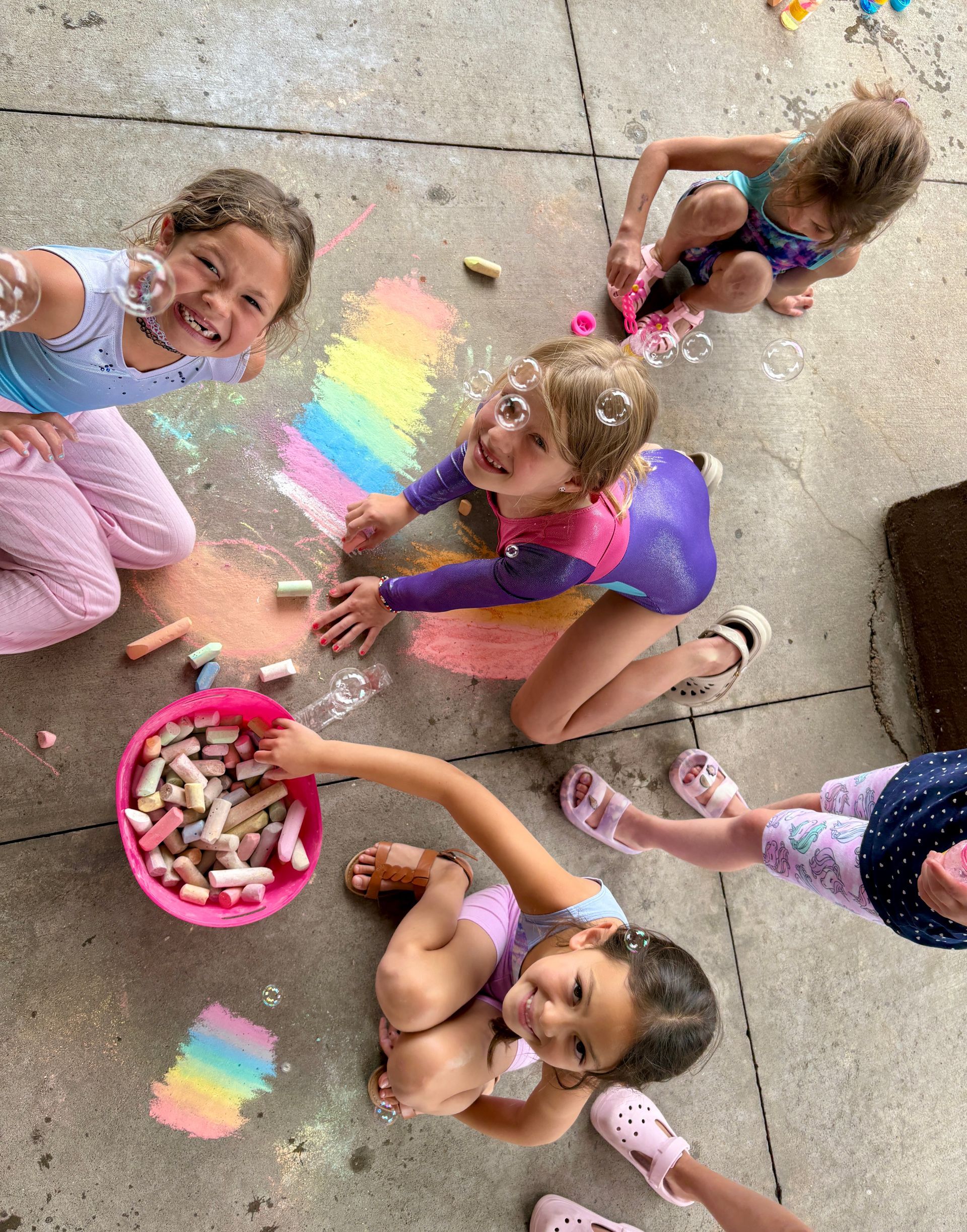 Young smiling campers gracing our patio with chalk illustrations