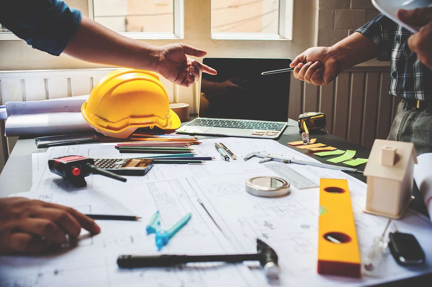 Engineers in Discussion with Construction Engineering Tools on Table — Shed Kits in Lismore, NSW