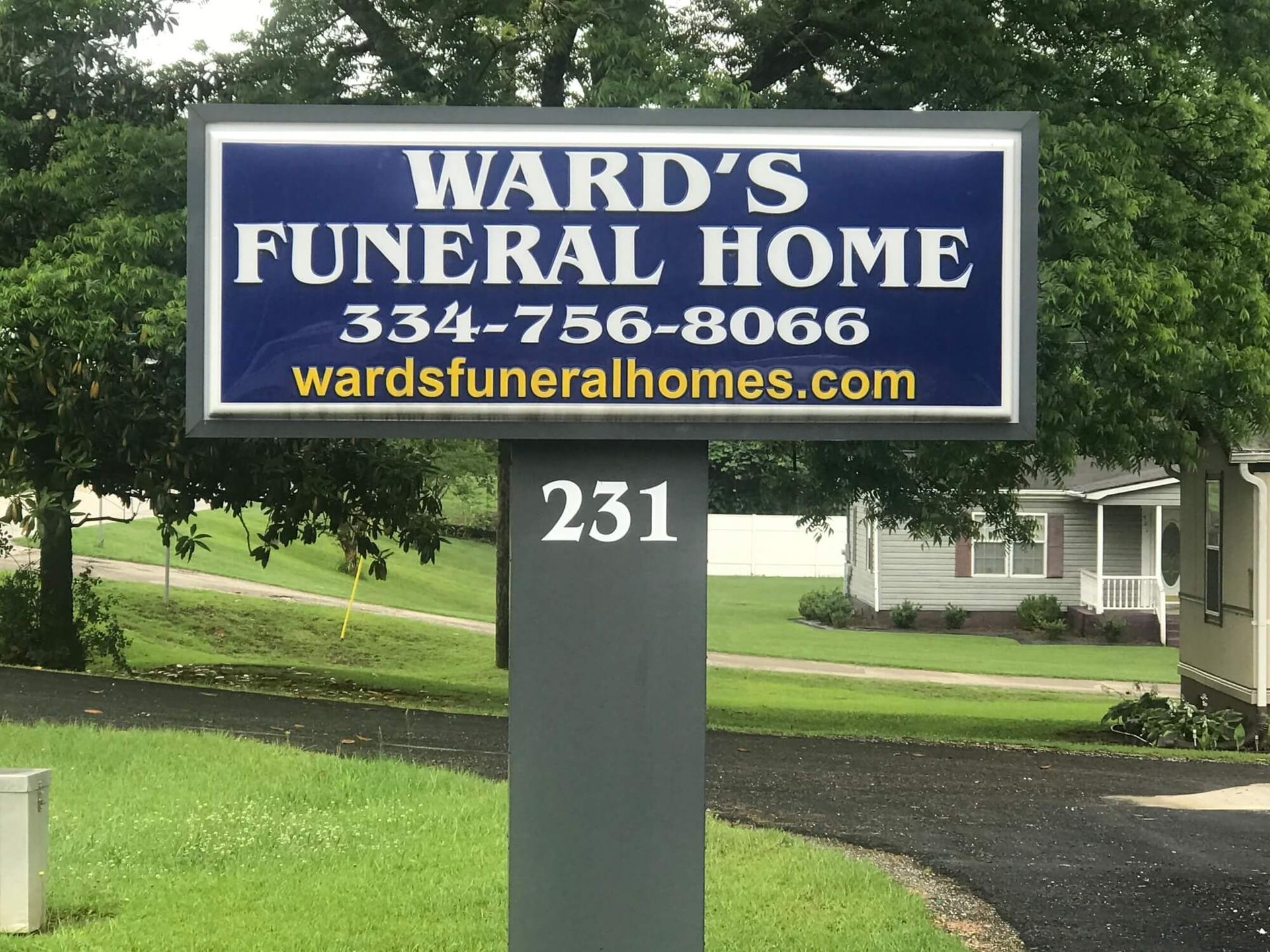 A sign for ward 's funeral home is in front of a house