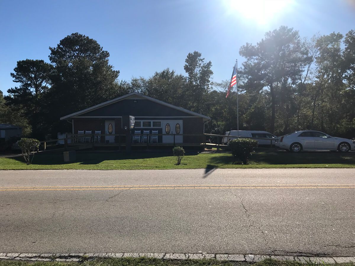 A white car is parked in front of a house