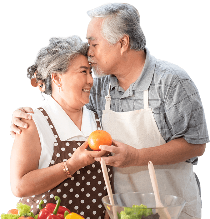 A man is kissing a woman on the cheek while she holds an orange.